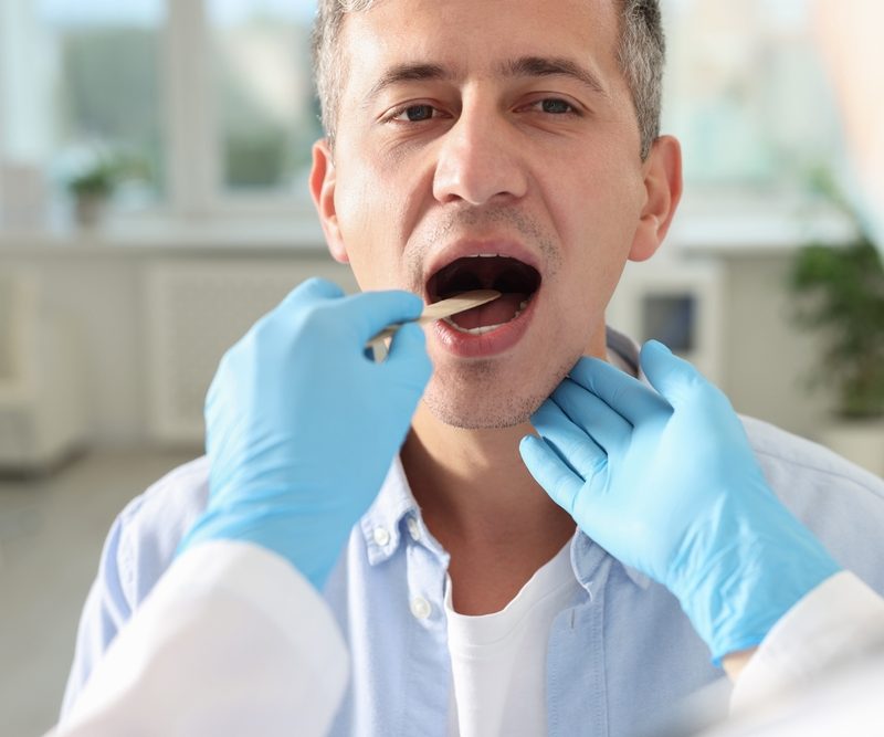 Dentist Examining Patient’s Mouth for Oral Irritation and Lesion – Painful Sore on Tongue
